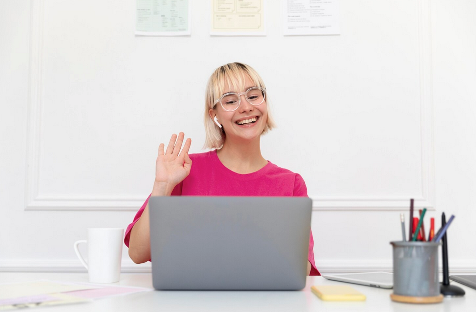 une page web s'affiche sur l'écran d'un ordinateur portable posé sur une table en bois. Un fauteuil, une table basse et une plante an arrière-plan.